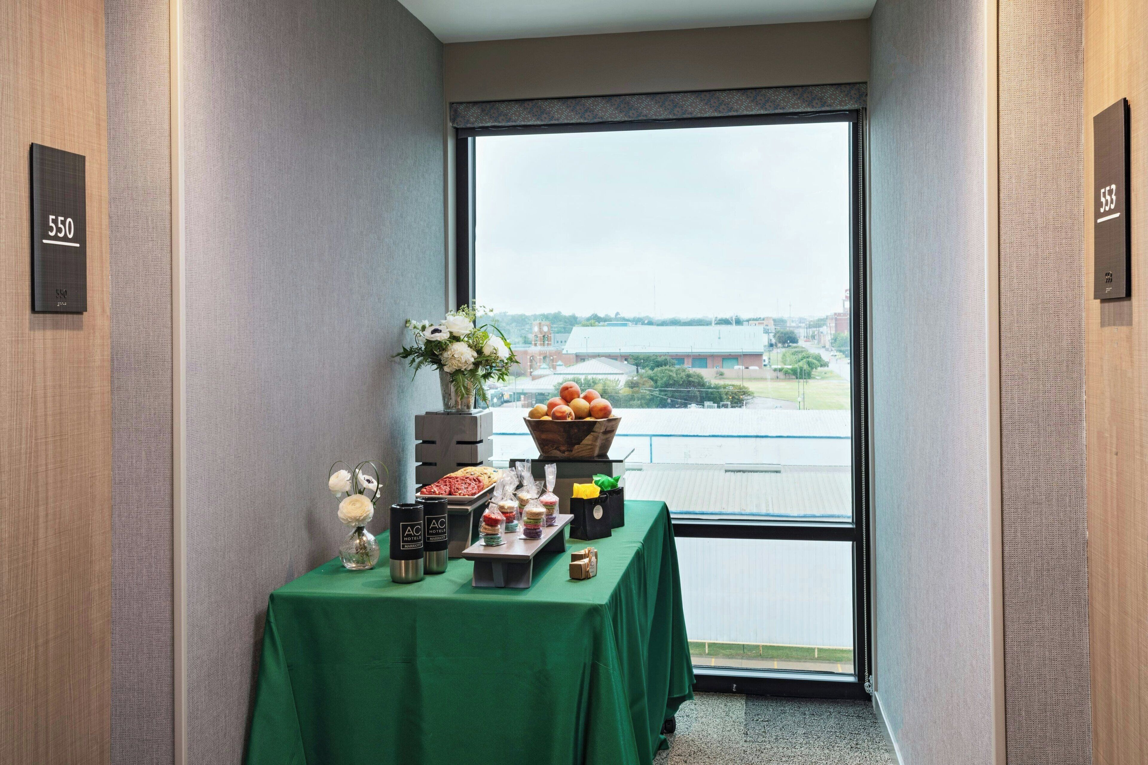 A room with a large window, a table with food items, and room numbers 550 and 553 on the walls.
