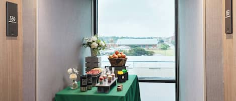 A room with a large window, a table with food items, and room numbers 550 and 553 on the walls.