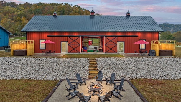 A rustic barn-style building with a gravel patio and outdoor seating area.