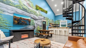 A modern interior with a fireplace, seating area, and a spiral staircase.