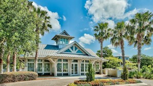 A modern hotel with a prominent tower, large windows, and a landscaped entrance. - "Shore Beats Work" Large Inlet Beach Home - Bikes (Inlet Beach)