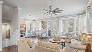 A spacious living room with a high ceiling fan, large windows with blinds, and a cozy seating area with a coffee table. - "Shore Beats Work" Large Inlet Beach Home - Bikes (Inlet Beach)