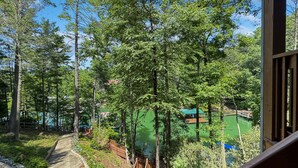 A wooden deck with a view of a lake and boats.