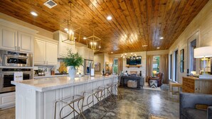 A spacious kitchen with a large island, stainless steel appliances, and a wooden ceiling. - The Overlook w/ Outdoor Pool, EV Outlet, Pickleball, Unbelievable Views (Broken Bow)