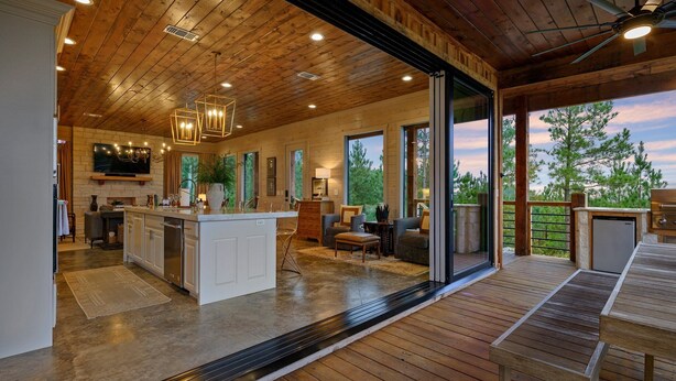 A spacious kitchen with a central island, large windows, and a wooden deck. - The Overlook w/ Outdoor Pool, EV Outlet, Pickleball, Unbelievable Views (Broken Bow)
