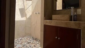 A modern bathroom with a shower, a sink, and a mirror. - Suite Zen con Jacuzzi y Terraza (Santiago de Querétaro)