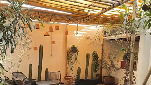 A hot tub in a covered outdoor area with chairs and potted plants. - Suite Zen con Jacuzzi y Terraza (Santiago de Querétaro)