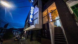 A modern hotel with a prominent neon sign, a visible staircase, and a clear view of the street outside. - Hotel Boutique Veracruz (Santa Rosa de Cabal)
