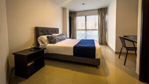 A hotel room with a bed, a bedside table, a chair, and a view of the outside through the window. - Hotel Boutique Veracruz (Santa Rosa de Cabal)