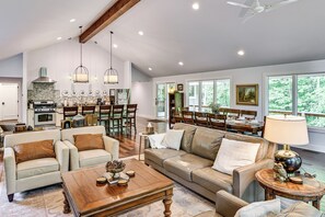 Un salon spacieux comprenant un grand canapé, une table basse et un coin repas avec une table et des chaises.