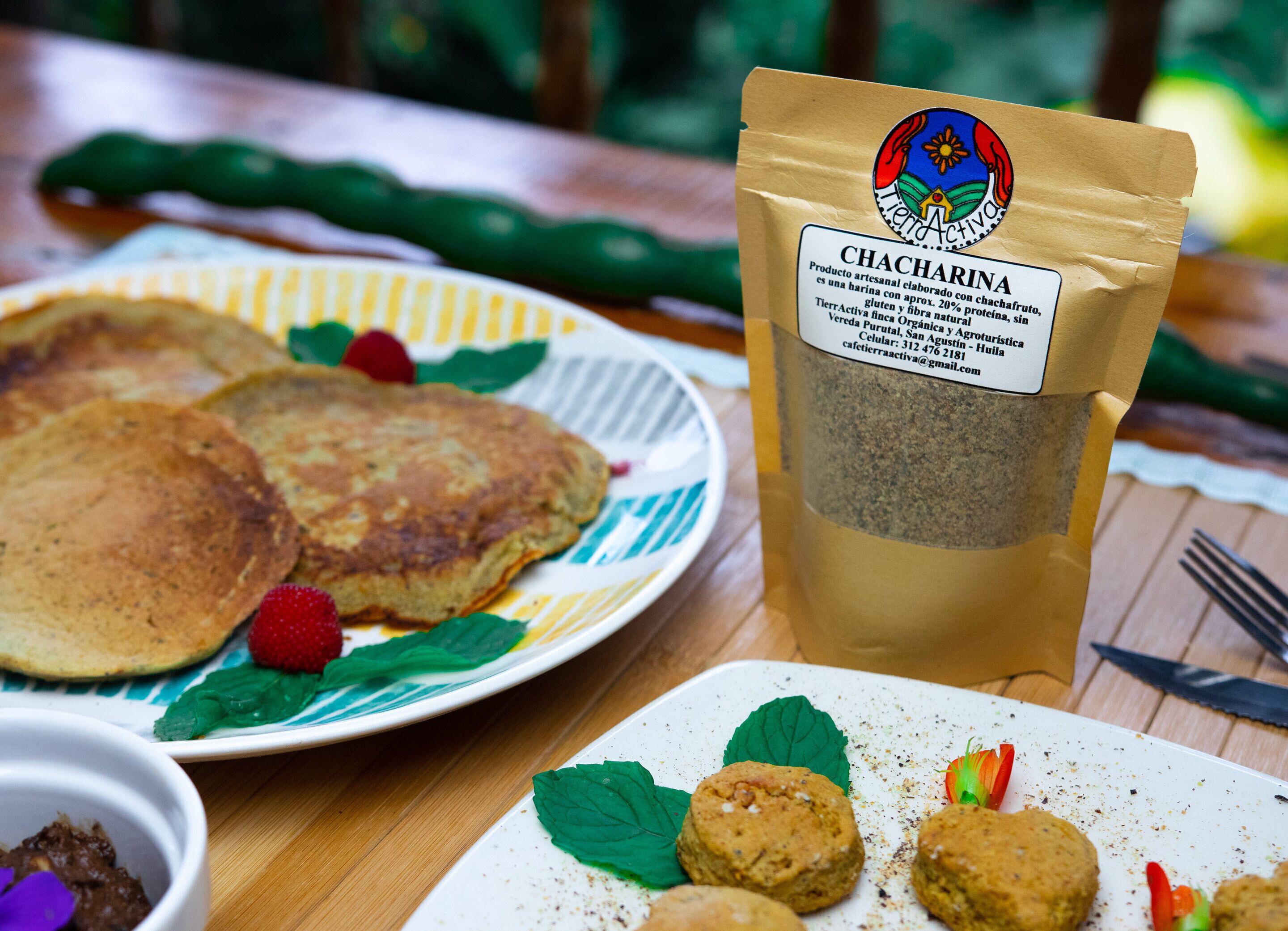 A breakfast setting with pancakes, a bag of Chacharina, and a plate of cookies.