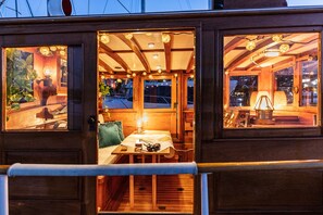 A cozy interior with wooden walls, a dining area with a table and chairs, and a seating area with a bench.