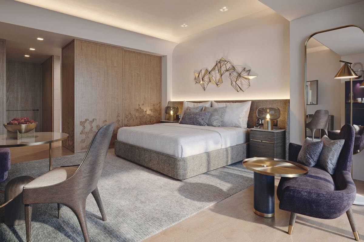 Een moderne slaapkamer met een groot bed, een nachtkastje, een stoel en een spiegel.