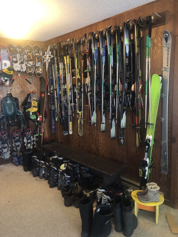 A ski storage room with skis and snowboards on racks and a bench. - Ski-On Ski-Off at Pico Mtn
Premier Slopeside House Rental. Dog Friendly!!! (Killington)