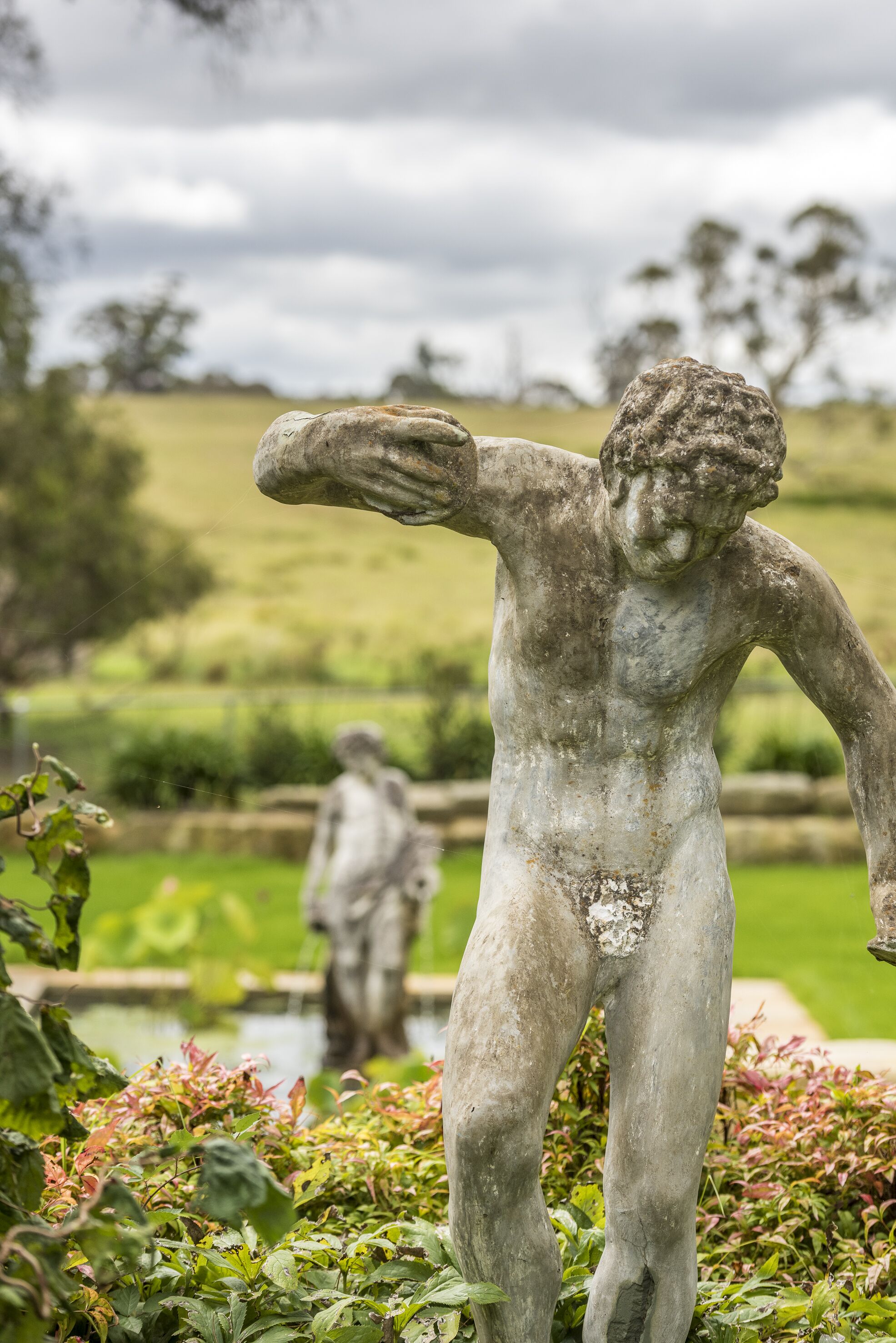 A statue of a classical figure in a garden setting.