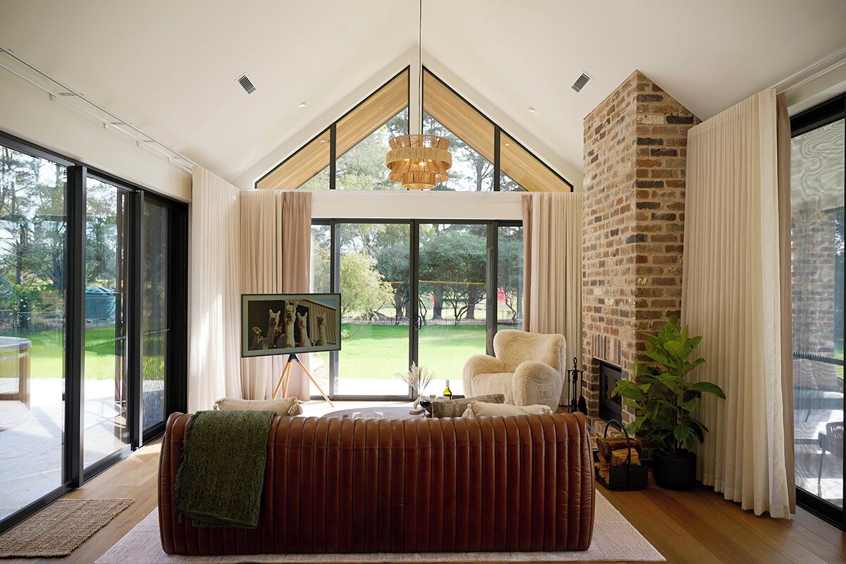 Ein modernes Wohnzimmer mit großem Fenster, Kamin und gemütlicher Sitzecke.
