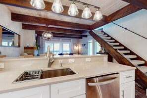 Enjoy cooking in this well-equipped kitchen with a central island, stainless steel sink, and dishwasher.