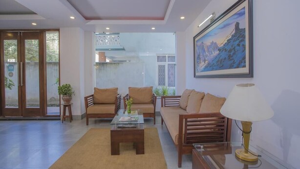 Un salón amplio con un conjunto de sofás, una mesa de centro y una lámpara.