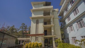 Un edificio de varios pisos con balcones y un acceso cubierto.