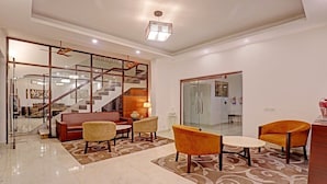 A modern interior with a staircase, seating area, and a glass partition. - Hotel Bel Morris (New Delhi)