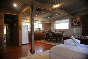 A room with a bed, a dining table with chairs, a kitchen area, and a large window. - studio apartment close to the ocean and countryside,
Takeover Target room (Meringo)