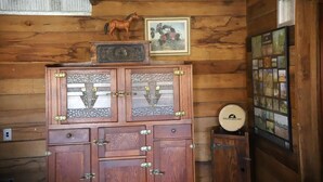 Ein Holzhütten-Innenraum mit einem Holzkasten, einem gerahmten Bild und einem wandmontierten Fotoalbum.
