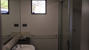 Ein modernes Badezimmer mit Waschbecken, Spiegel und Dusche.