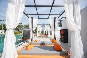 A poolside area with white canopies, orange cushions, and a clear view of the pool. - Wonderland Suites and Resort (Prey Nob)