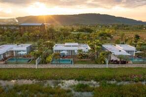 A resort with multiple buildings, outdoor pools, and lush greenery.