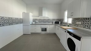 Cozinha equipada com máquina de lavar, micro-ondas e torradeira.