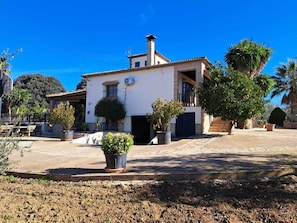 A two-story building with a white facade, a chimney, and a balcony. - Albarracín Rural House (Setenil de las Bodegas)