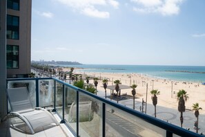 Un balcon avec vue sur une plage et l’océan.