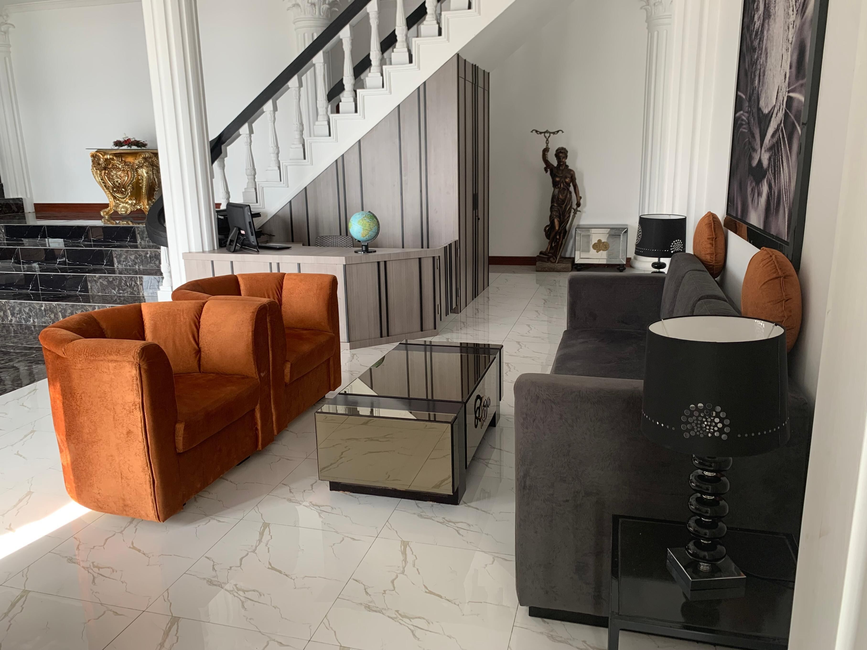 Un salon moderne avec un canapé, une table basse et une lampe.