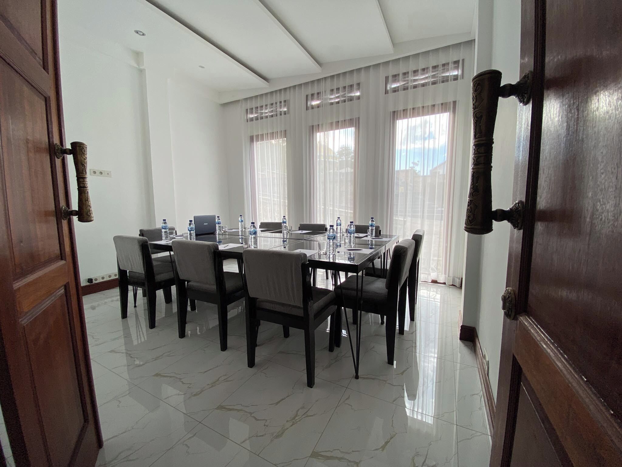 A conference room with a large table, chairs, and a laptop.