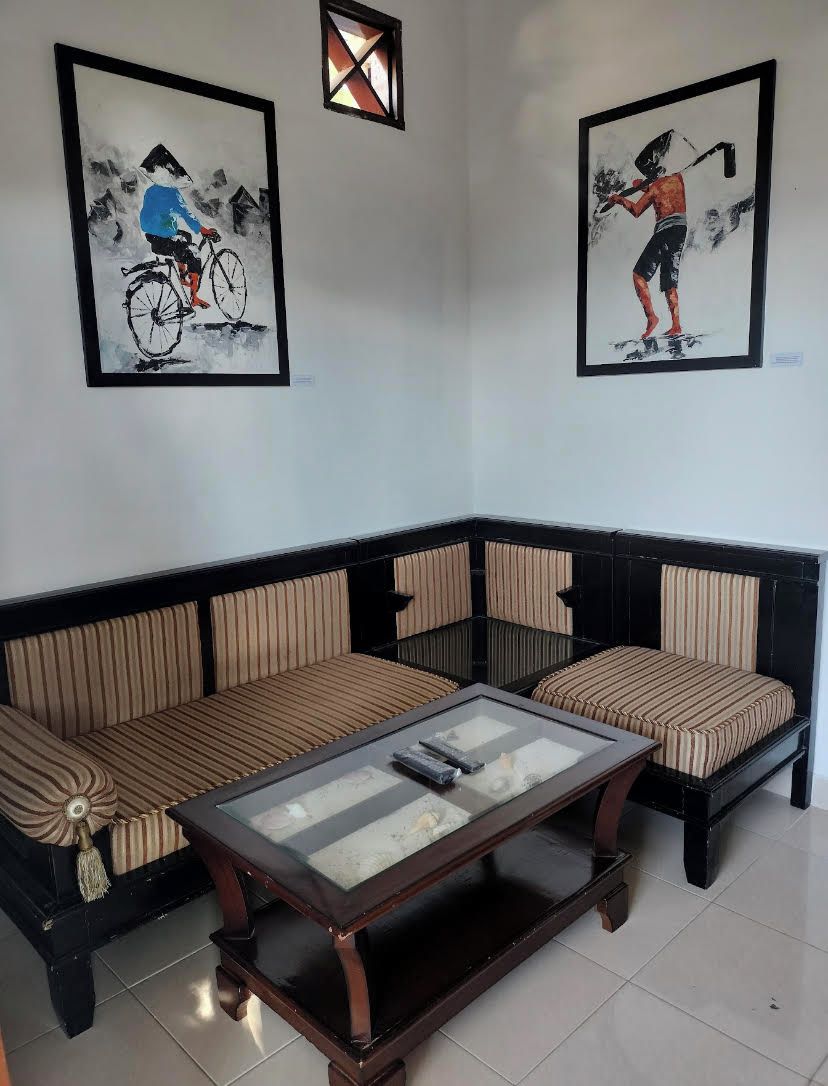 A living room with a sofa, a coffee table, and two framed artworks on the wall.