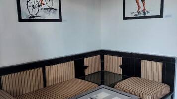 A living room with a sofa, a coffee table, and two framed artworks on the wall.