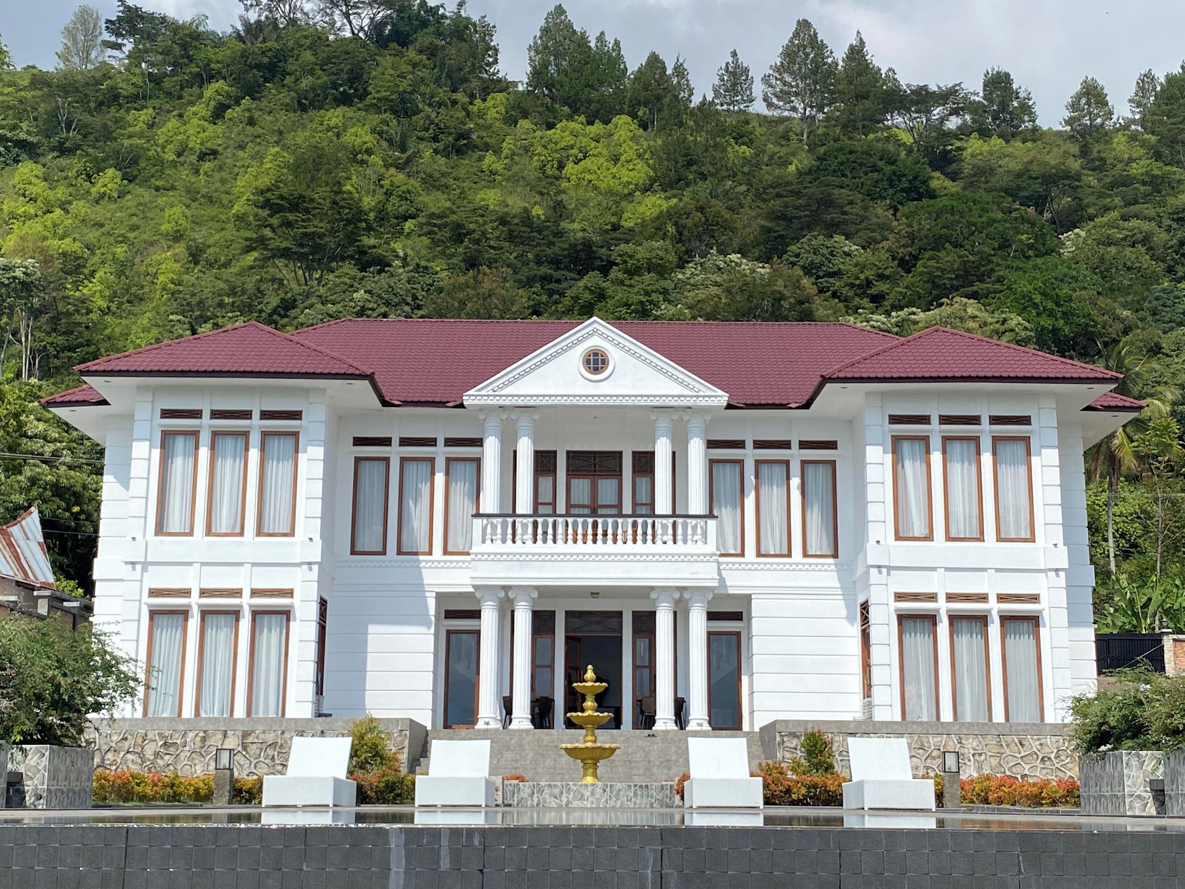 A two-story building with a symmetrical facade, large windows, and a central balcony.