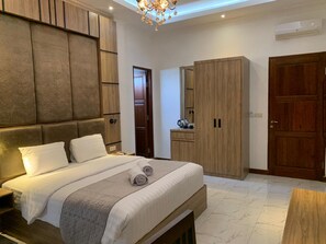Une chambre à coucher moderne avec un grand lit, une armoire en bois et une armoire intégrée dotée d’un miroir.