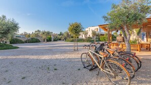 A gravel driveway leading to a building with a pergola and benches. - Cava Li Santi Residence - Villa La Cava | Appartamento Deluxe (Santa Caterina)