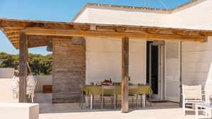 An outdoor patio with a table set for dining, surrounded by chairs and a pergola structure. - Cava Li Santi Residence - Villa La Cava | Appartamento Deluxe (Santa Caterina)
