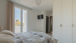 A bedroom with a bed, a TV, and a wardrobe. - Cava Li Santi Residence - Villa La Cava | Appartamento Deluxe (Santa Caterina)