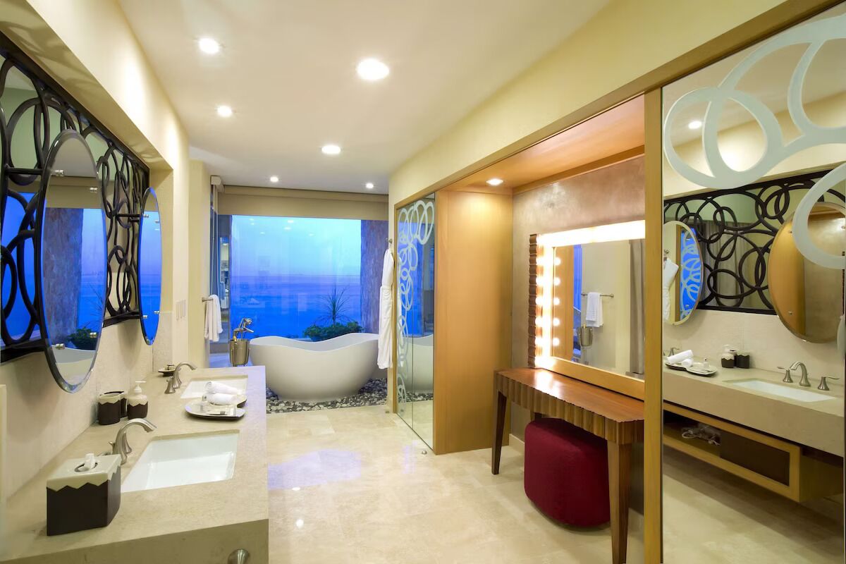 Une salle de bain moderne avec un grand miroir, un meuble-lavabo et une baignoire.