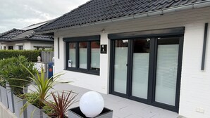 Een modern gebouw met een pannendak, grote ramen en een nummerbord met daarop kamer 6.