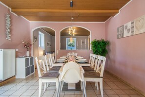 A dining area with a long table set for four, surrounded by chairs. - Holiday Apartment "Fewo 2 - Osterberg" with Private Terrace, Shared Garden & Wi-Fi (Liebenau)