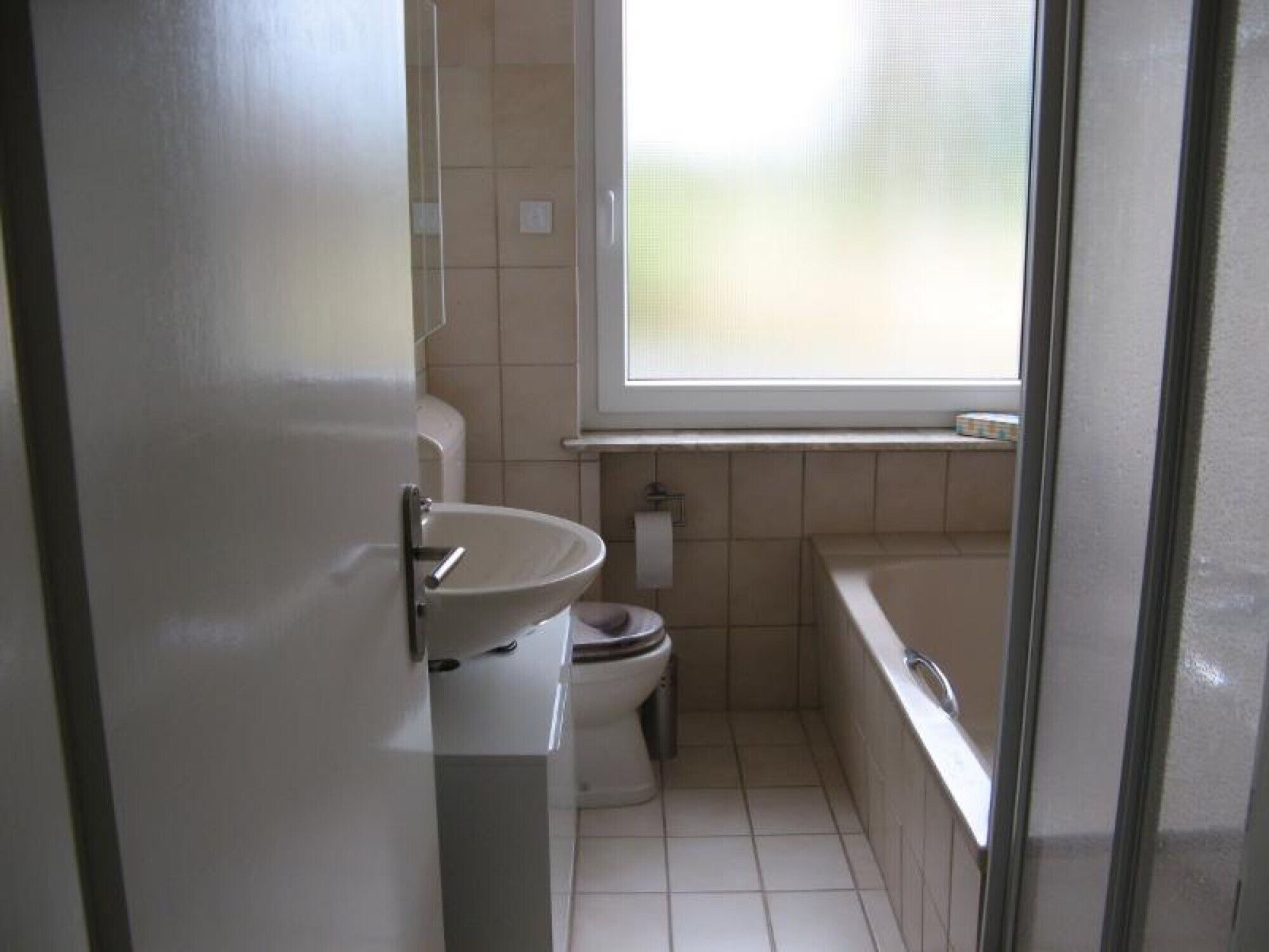 Un baño pequeño con inodoro, lavabo y bañera.