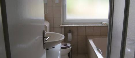 Un baño pequeño con inodoro, lavabo y bañera.