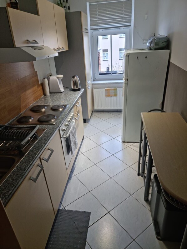 Cocina compacta con estufa, horno y refrigerador.