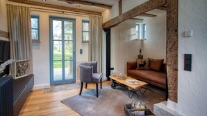 Una sala de estar con sofá, sillón, mesa de centro y chimenea.
