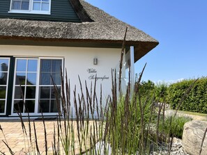 A villa with a thatched roof, a large window, and a sign reading 'Villa Logenfret.' - Holiday Home 'Villa Sorgenfrei' with Lake View, Private Terrace and Wi-Fi (Zinnowitz)