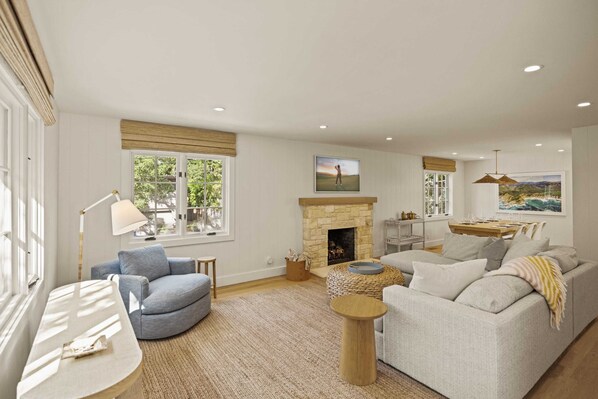 A living room with a fireplace, a sofa, a coffee table, and a lamp.